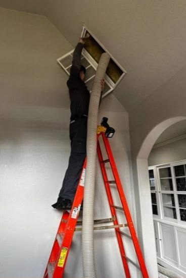 Technician cleaning a ceiling air return - Clovis, CA 93612